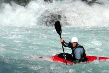 whitewater kayaker battling through intense rapid